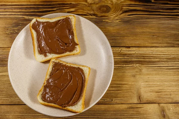 Twee sneetjes brood met heerlijke hazelnoot op houten tafel. Bovenaanzicht — Stockfoto