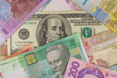 Ukrayna Hryvnia banknotlarının arka planında 100 dolarlık banknot