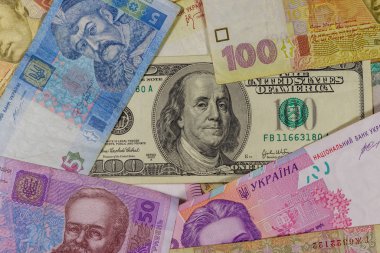 Ukrayna Hryvnia banknotlarının arka planında 100 dolarlık banknot