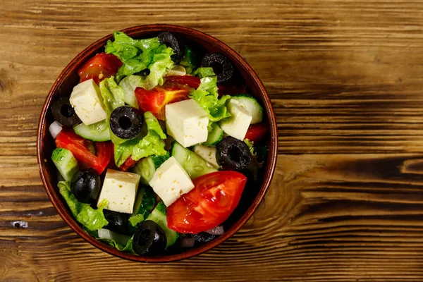 Taze sebzeli Yunan salatası, beyaz peynir ve ahşap masada siyah zeytin. Üst görünüm — Stok fotoğraf