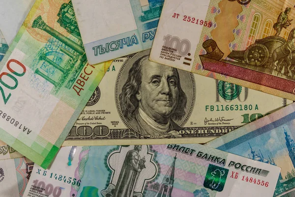 Сто долларов купюры на фоне российских рублей банкноты — стоковое фото