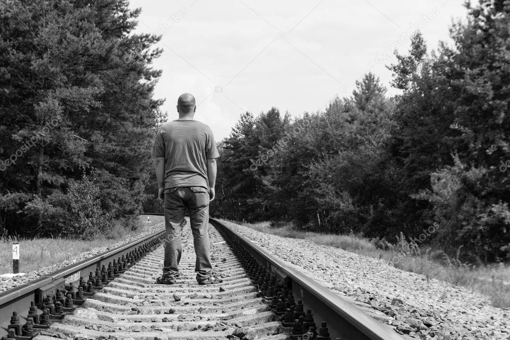 Lonely man walking on a railway track. Black and white tone