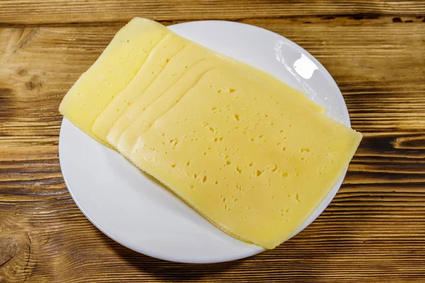 Tahta masadaki bir tabakta peynir dilimleri. Üst görünüm — Stok fotoğraf