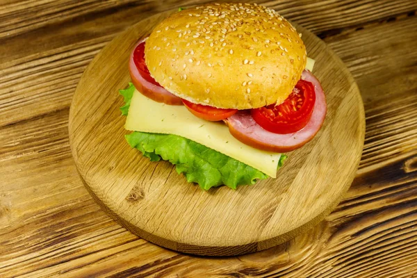 Fresh delicious homemade cheeseburger on wooden table — Stock Photo, Image