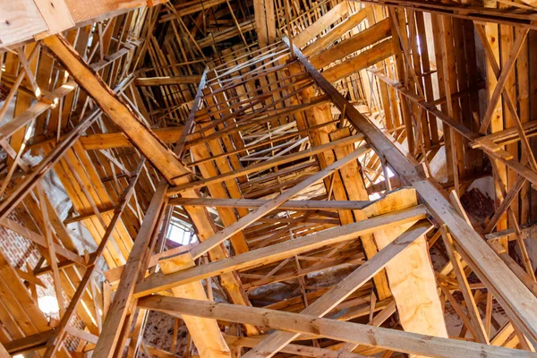 Wooden scaffolding inside building during renovation works. Looking up