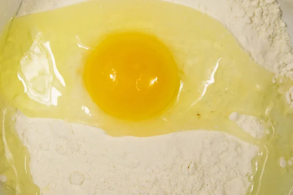 Разбитые яйца на муке крупным планом — стоковое фото