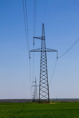 Mavi gökyüzüne karşı yüksek voltajlı güç hattı