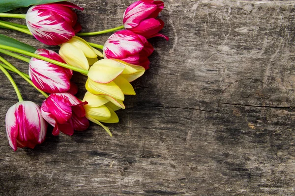 Red and yellow tulips on rustic wooden background with copy spac — Stock Photo, Image