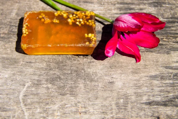 Ręcznie robione mydło i kwiat czerwony tulipan na rustykalne drewniane tła — Zdjęcie stockowe