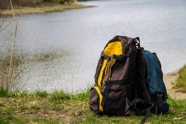 Dva turistické batohy na břehu řeky. Koncept túry — Stock fotografie