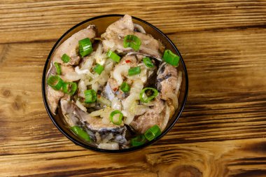 Ahşap masada cam kasede marine edilmiş sazan balığı. Üst görünüm