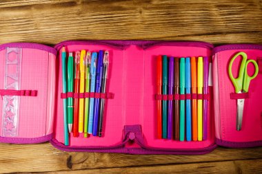 Kalem, kalem, keçeli kalem, makas ve cetvel içeren tahta masa. Üst görünüm