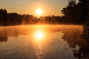 Gün doğumunda sisli nehir manzarası. Sabaha karşı sisli