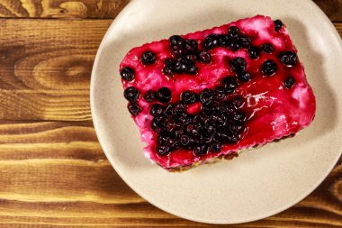 Ahşap masa üzerinde siyah frenk üzümü ile lezzetli cheesecake. Üstte görüntü