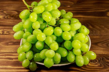 Tahta bir tabakta taze beyaz üzüm.