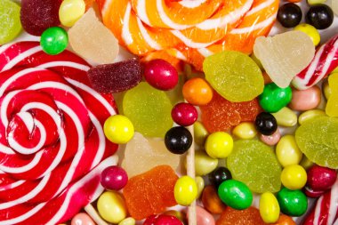 Renkli çikolata şekerleri, lolipoplar, şeker kamışı ve jöleli şekerlerin arka planı