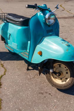 Şehrin caddesinde park etmiş mavi scooter.