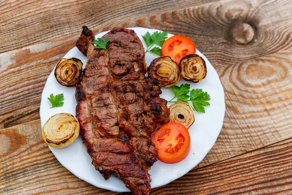 Grillad Fläskfilé Med Lök Tomat Och Persilja Vit Platta Träbord — Stockfoto