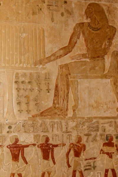 Ancient egyptian paintings and hieroglyphs carved on the stone wall