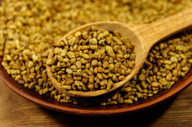 Ahşap masa üzerinde seramik tabakta çemen tohumu