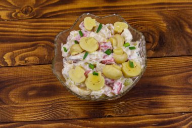 Ahşap masada marine mantar, sosis, soğan ve mayonez ile patates salatası