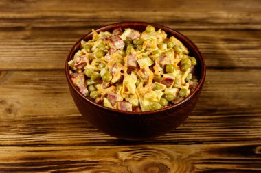 Sosis, bezelye, havuç ve soğan ahşap masa üzerinde mayonez salatası