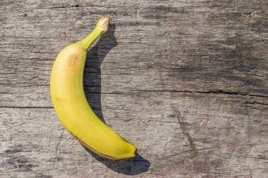 Kırsal ahşap masada lezzetli, olgun, sarı muz meyvesi. Üst görünüm