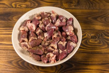 Ahşap masada çiğ tavuk kalpleri. Üst görünüm