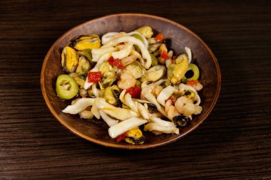 Tahta masada karides, mürekkep balığı ve midye ile deniz ürünleri salatası.