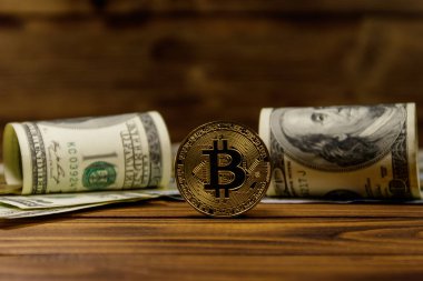 Altın bitcoin ve ahşap arka planda dolar