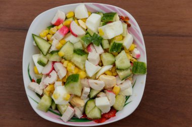 Yengeç sopa, tatlı mısır, salatalık ve ahşap masa üzerinde yumurta salatası. Üstten Görünüm