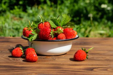 Tahta bir masada taze olgun çilek.