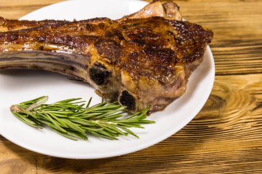 Biberiyeli biftek ve beyaz tabakta ahşap masa.