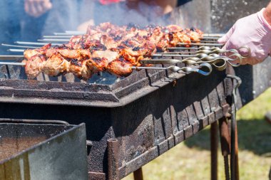 Metal şişte pişen ızgara kebap. Barbeküde kızartılmış et. Geleneksel doğu yemeği, şiş kebap. Kömür ve alevler üzerine ızgara, piknik, sokak yemekleri