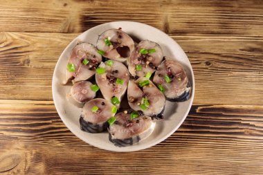 Tahta masada baharatlı dilimlenmiş uskumru. Tabakta tuzlu scomber.