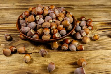 Tahta bir masada seramik tabakta fındıklar