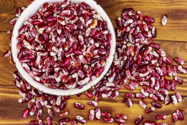 Ahşap masada beyaz eski emaye kase ham böbrek çekirdekleri