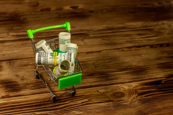 Pequeño Carrito Compras Con Rollos Billetes Cien Dólares Sobre Fondo —  Fotos de Stock