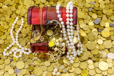 Altın sikke ve mücevherlerle dolu eski bir hazine sandığı.