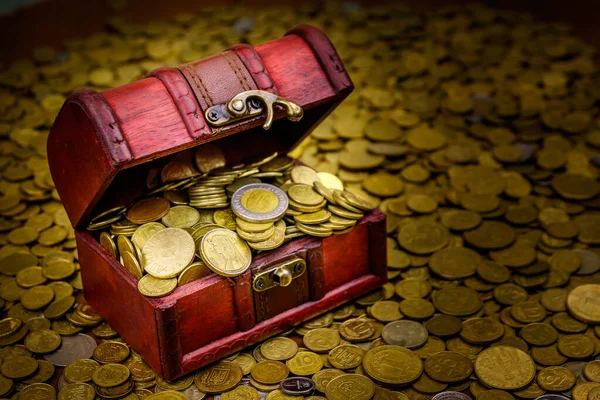 Vintage treasure chest full of gold coins on a background of golden coins