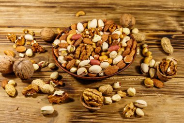 Tahta masada karışık fındık. Ceviz, fıstık, badem, fıstık, fındık, seramik kasede fındık. Sağlıklı yeme kavramı
