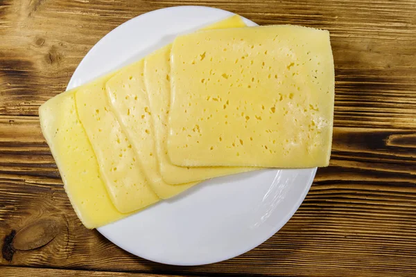 Rebanadas Queso Plato Sobre Una Mesa Madera Vista Superior —  Fotos de Stock