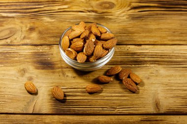 Kırsal bir masada cam kasede badem.