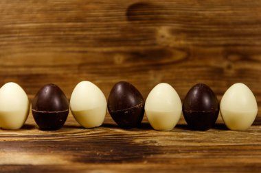 Tahta masada küçük çikolatalı şekerler. Ahşap arka planda çikolatalı paskalya yumurtaları