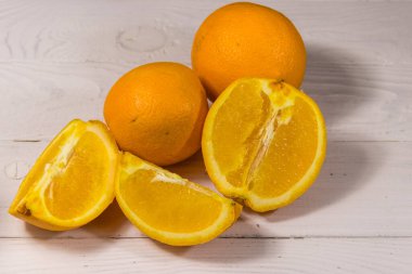 Beyaz ahşap masada taze portakallar.