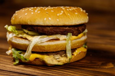 Ahşap masada lezzetli büyük hamburger.