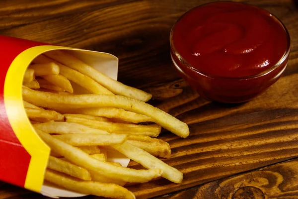 法式薯条加番茄酱放在木制桌子上 — 图库照片