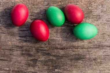 Kırsal ahşap zemine boyanmış Paskalya yumurtaları. Üst görünüm, alanı kopyala