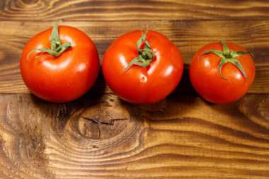 Ahşap masada taze olgun domates. Üstteki görünüm, kopya alanı