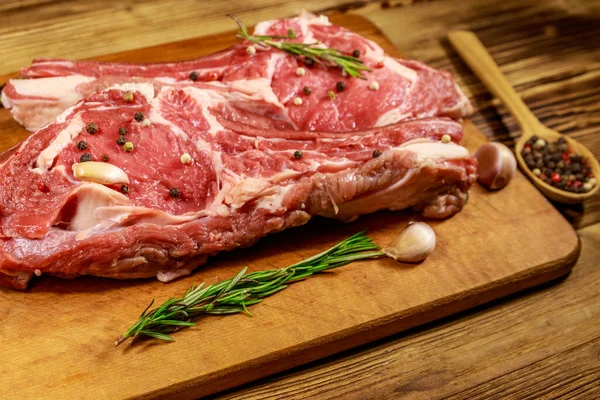Kemiğin Üzerine Çiğ Biftek Baharatlar Sarımsak Ahşap Masada Biberiye — Stok fotoğraf